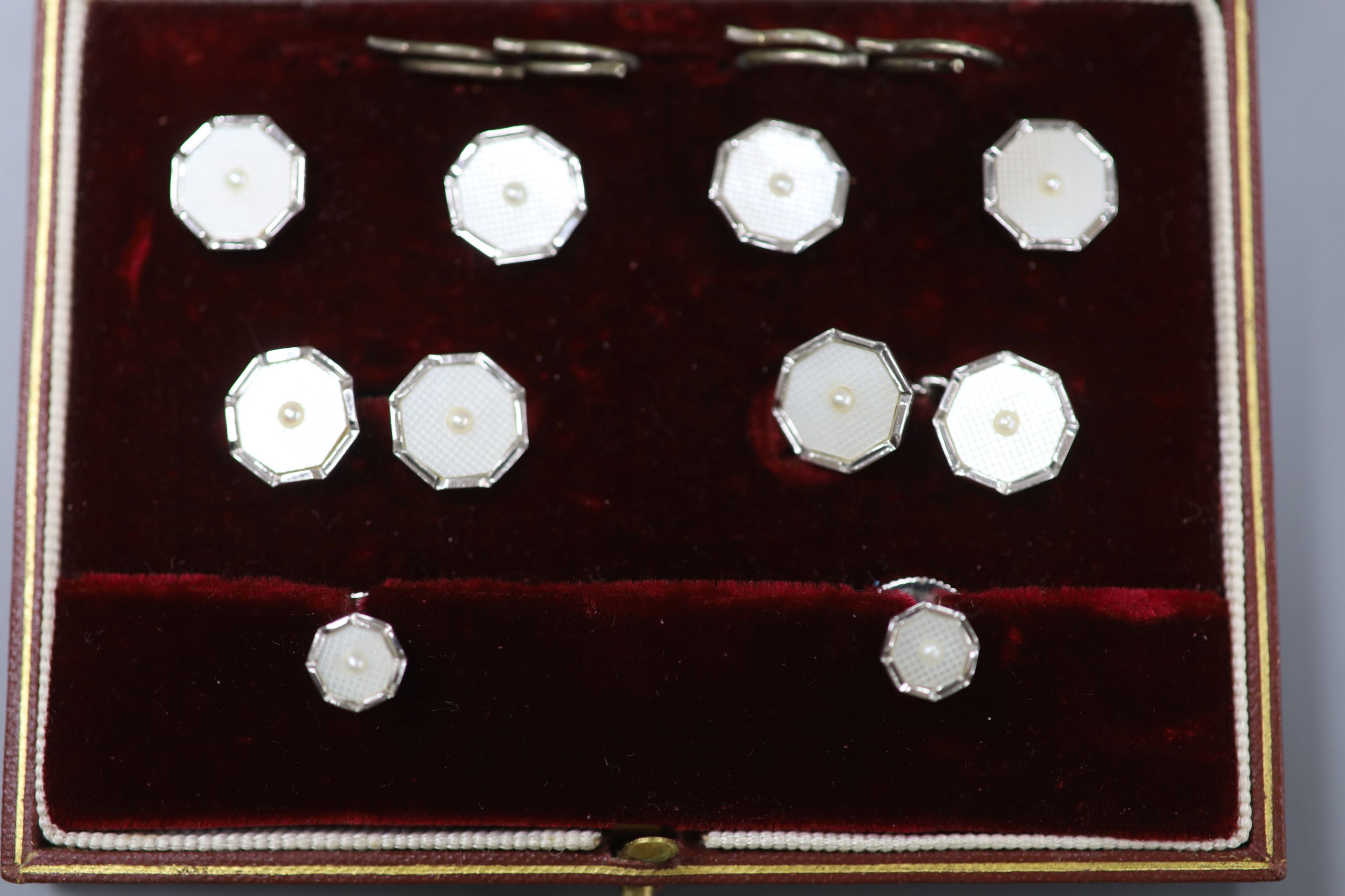 A gentlemens 9ct white gold and mother of pearl dress set of octagonal form, cased,